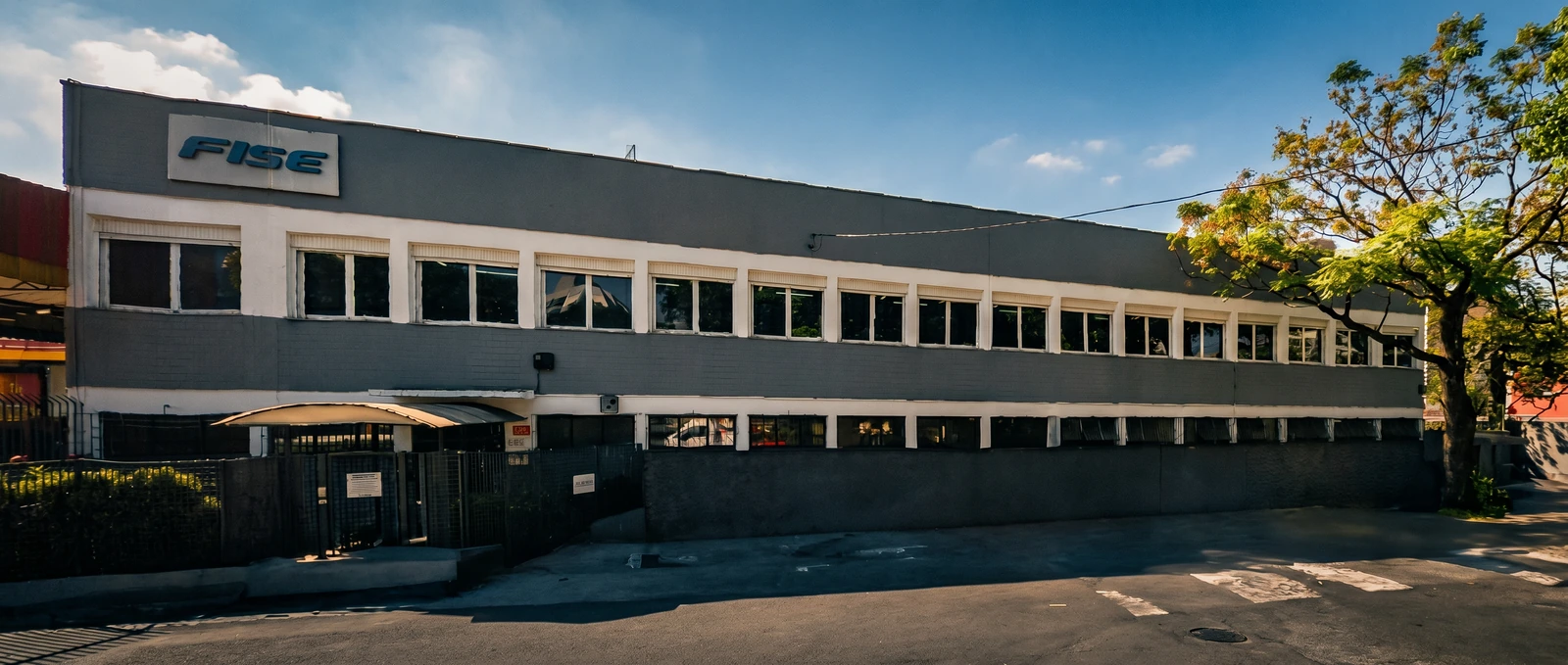 Fachada da unidade FISE em São Paulo, com a marca sobre a entrada e as janelas do edifício industrial.