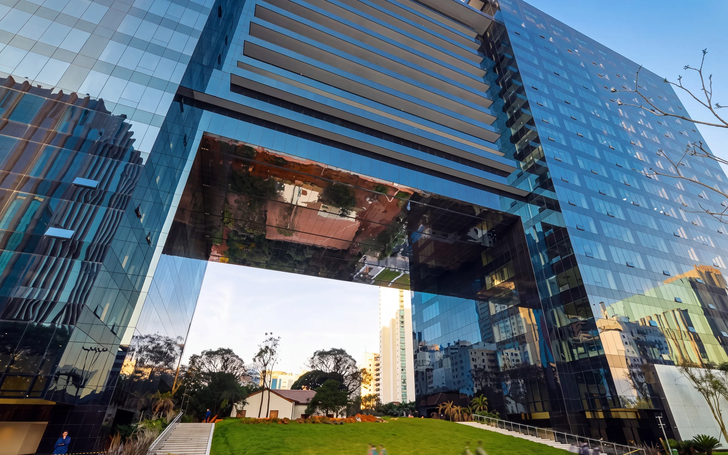 Edifício Pátio Victor Malzoni, com fachadas de vidro e grande vão sobre o jardim.